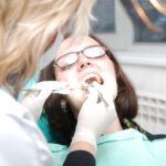 girl laying in dental chair having her teeth examined