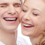 man and woman smiling with cheeks pressed against each other