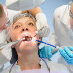 senior woman laying in dental chair having her teeth examined