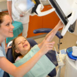 Dentist showing child dental procedure on monitor