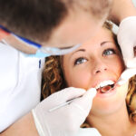 girl having her teeth examined by dentist