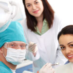 dentist, dental assistant and patient smiling