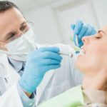 dentist examining female patients teeth