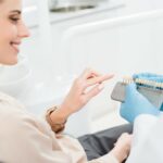 dentist showing woman dental implants