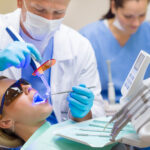 Dentist using UV lamp female patient