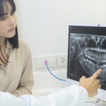 A dentist explaining teeth x-ray to a woman in dental clinic
