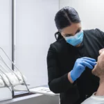 dentist checking on male patients teeth