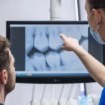 dentist and dental assistant looking at a patients xrays
