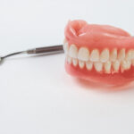dental mirror and artificial teeth on a white background